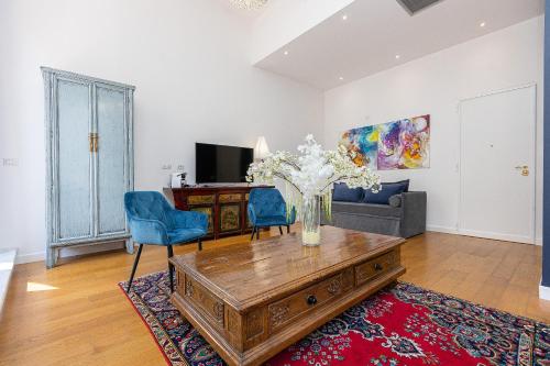 a living room with a vase of flowers on a coffee table at Suite della Pigna in Rome