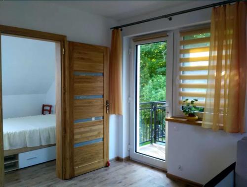 a room with a door and a bed and a window at Apartament Mazurski Rodowo in Sorkwity