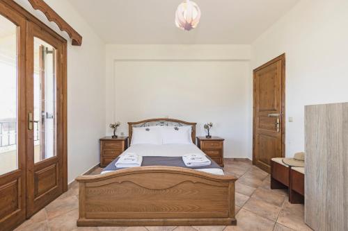 a bedroom with a bed and a wooden door at VILLA KONSTANTINA Sidari in (( Sgoúrna ))