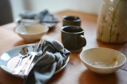 a wooden table with bowls and utensils on it at Maison 1686 in Niedernai