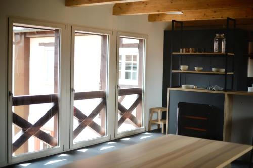 a kitchen with sliding glass doors and a table at Maison 1686 in Niedernai