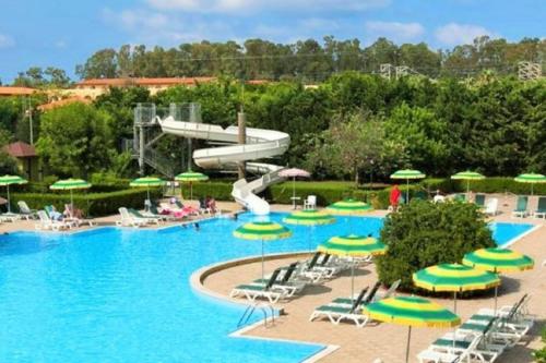 una piscina del resort con scivolo, sedie e ombrelloni di Pizzo Beach Club a Pizzo