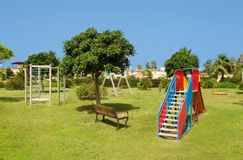 a park with a playground with a slide and a bench at Pizzo Beach Club in Pizzo