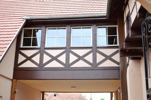 a wooden garage door with windows on a building at Maison 1686 in Niedernai