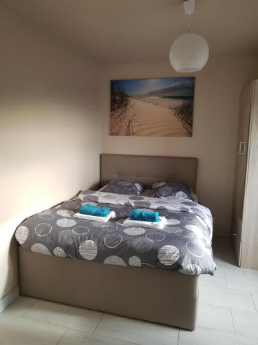 un lit dans une chambre avec un tableau sur le mur dans l'établissement 2/3 Pièces - Balcon Vue Mer - Parking, à Trouville-sur-Mer