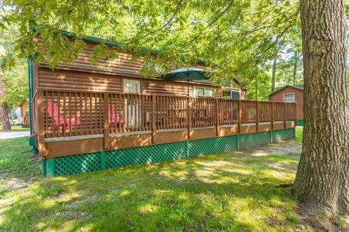 a house with a deck with two chairs and a tree at Pine Haven in Cape May Court House