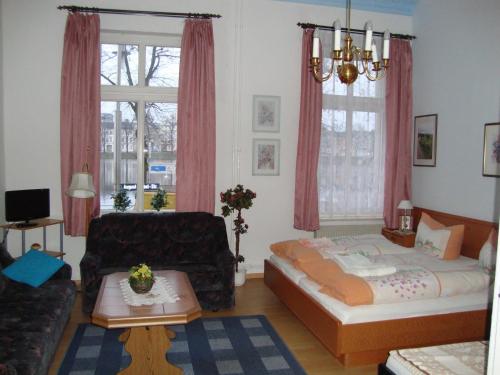uma sala de estar com uma cama e um sofá em Haus am Pfaffenteich em Schwerin