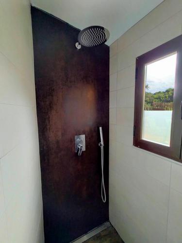 a bathroom with a black door with a window at El cielo de las Pajaritas in Pasarón