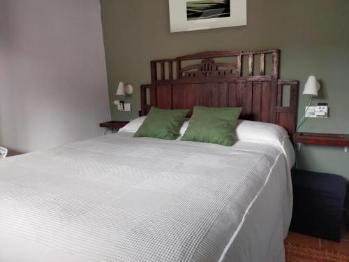 a bedroom with a large white bed with green pillows at El cielo de las Pajaritas in Pasarón