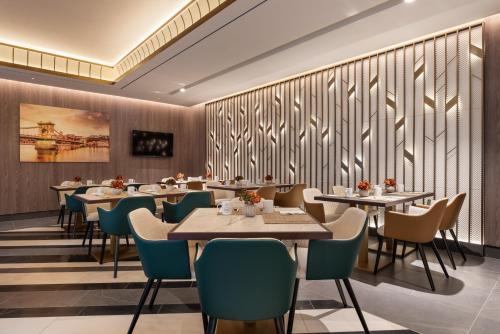 a dining room with tables and chairs and a wall with wood at Eurostars Ambassador in Budapest