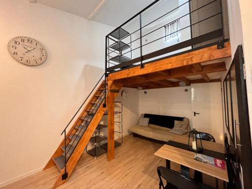 une mezzanine avec un escalier et une horloge dans l'établissement Grand studio contemporain avec mezzanine, à Sérignan