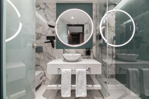 a bathroom with a sink and two mirrors at Eurostars Ambassador in Budapest
