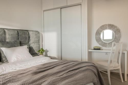 a bedroom with a bed and a mirror and a chair at Villa Bala - Seaside Luxury Villa! in Zakynthos Town