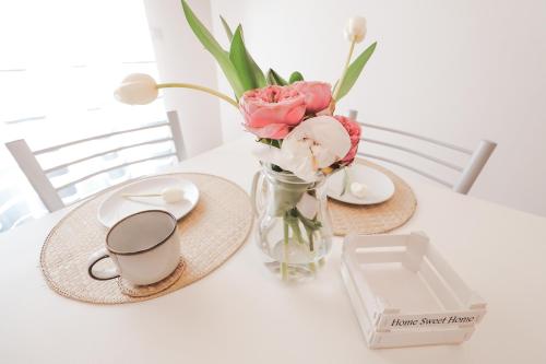a table with a vase of flowers and a cup of coffee at Acquasanta Relais in Laureana Cilento