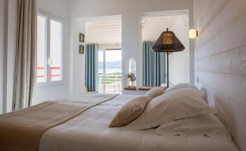 a white bedroom with a large bed with a window at Grand Hôtel Du Lido in Argelès-sur-Mer