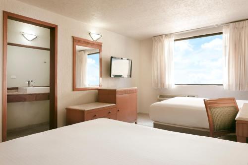 a hotel room with two beds and a sink at Gamma Villahermosa Centro in Villahermosa