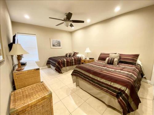 a bedroom with two beds and a ceiling fan at Suntide I Condos W101 in South Padre Island