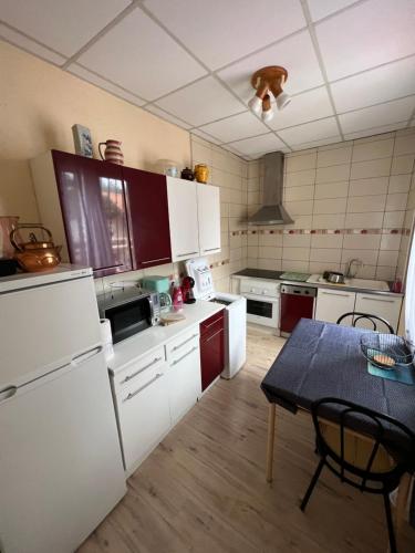 - une cuisine avec des appareils électroménagers blancs et une table dans l'établissement Grand F3 vue mer centre plage proche commerces, à Plage dʼArgelès