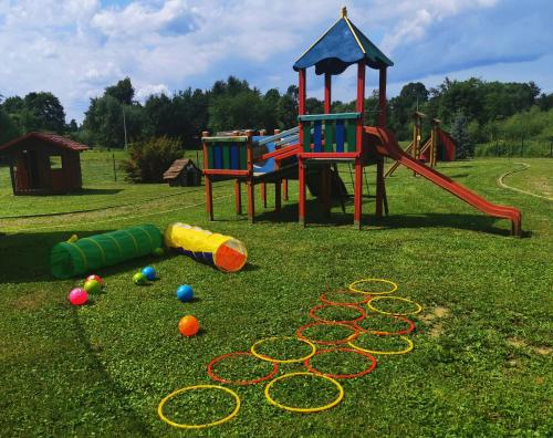 a playground with two play equipment on the grass at Domek rekreacyjny in Odrzechowa