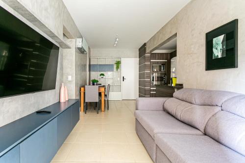 a living room with a couch and a table at Apto 2 quartos deslumbrante com piscina - Centro in Florianópolis