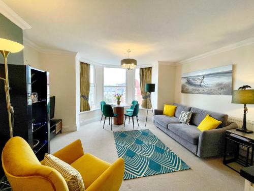a living room with a couch and a table at Beautiful chic apartment, lift, views & parking in Scarborough
