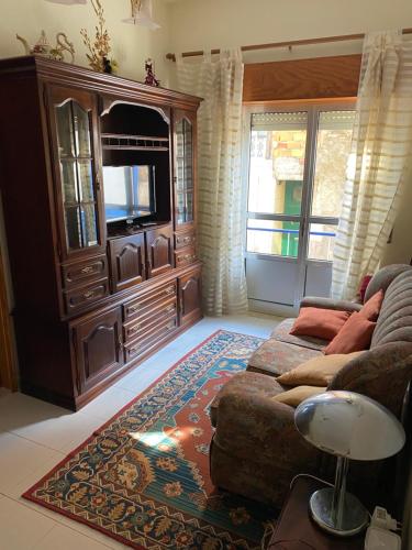 a living room with a couch and a entertainment center at Casa Glória in Tomar