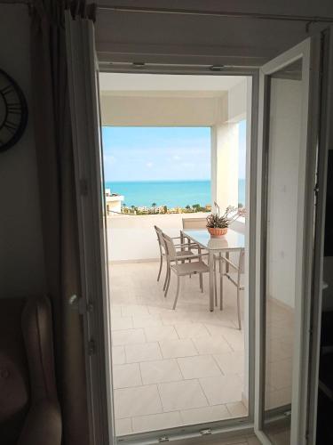 an open door to a patio with a view of the ocean at Thea Apartment in Agia Marina Nea Kydonias