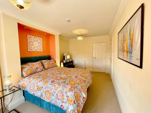una camera da letto con un letto con una parete arancione di Beautiful chic apartment, lift, views & parking a Scarborough