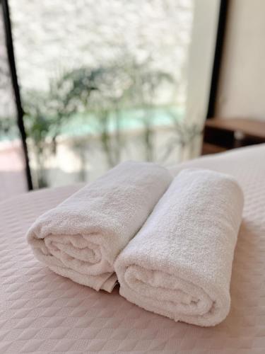 a stack of towels sitting on top of a bed at La Veleta luxury condos in Tulum