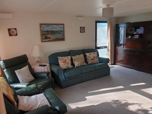 ein Wohnzimmer mit einem Sofa und einem Stuhl in der Unterkunft The Homestead, Cliff-en-Howe Rd, Pott Row, Kings Lynn in Grimston