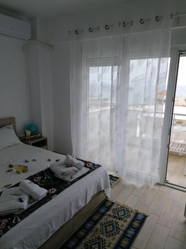 a bedroom with a bed and a large window at Crystal Blue Apartments in Nea Kalikratia