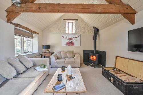 a living room with a couch and a fireplace at Heale Farm Cottage in Trentishoe