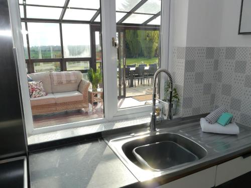 - un évier de cuisine avec vue sur le patio dans l'établissement South View Country House Sleeps 12 - Hot Tub - Views, à Henley in Arden
