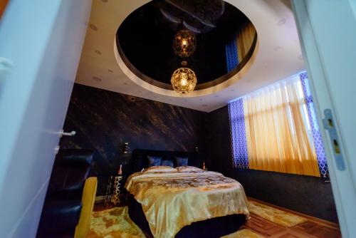 een slaapkamer met een bed en een kroonluchter bij ELENA LUX 2 in Užice
