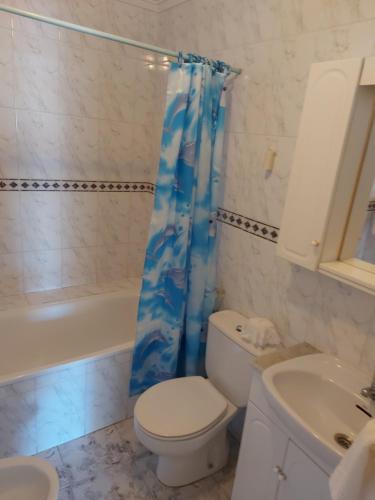 a bathroom with a toilet and a sink and a shower curtain at Fuensanta 400m to Beach Med Syndicate 10 in Torrevieja