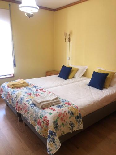 a bedroom with two beds with blue pillows at Two bedroom apartment near beach and Casino in Figueira da Foz