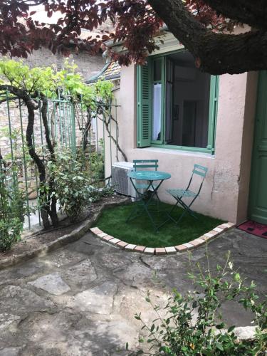 eine Terrasse mit einem Tisch und einem Stuhl vor einem Haus in der Unterkunft LE BEFFROI in Millau