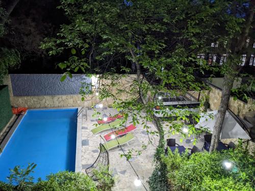 een uitzicht over een zwembad met stoelen en bomen bij Sani Hotel in Tbilisi City