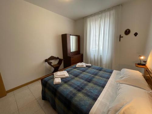 1 dormitorio con cama, tocador y espejo en Cozy apartment with private parking on Domaso's lakeside - Larihome A09, en Domaso