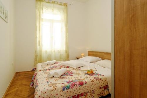 1 dormitorio con 1 cama con sábanas blancas y ventana en Apartment Eliana, en Zadar