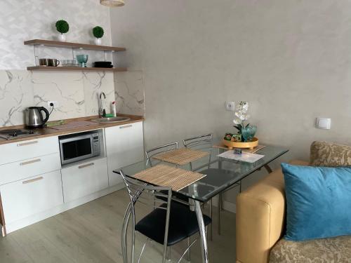 een kleine keuken met een tafel en een bank bij Арбат apartment in Alma-Ata