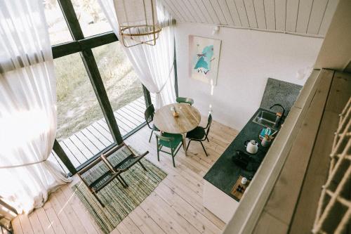 einen Blick über ein Zimmer mit einem Tisch und Stühlen in der Unterkunft Pazust Latgalē Country Houses in Skaista