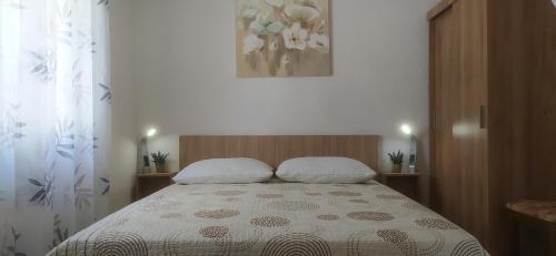 een bed met 2 kussens in een kleine kamer bij Kuća Jakov in Nerežišće