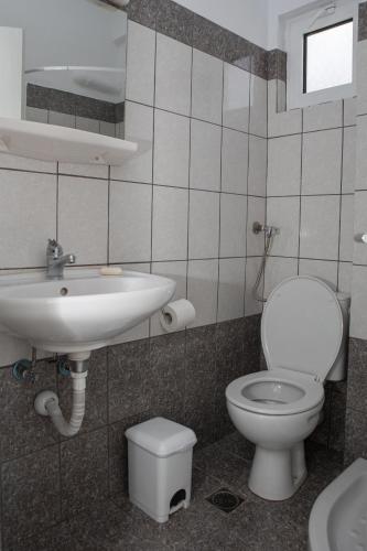 a bathroom with a toilet and a sink at Ronzi Apartments in Kamena Vourla
