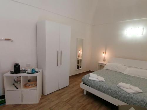 una camera bianca con letto e armadietto bianco di Cassiopea a Gaeta
