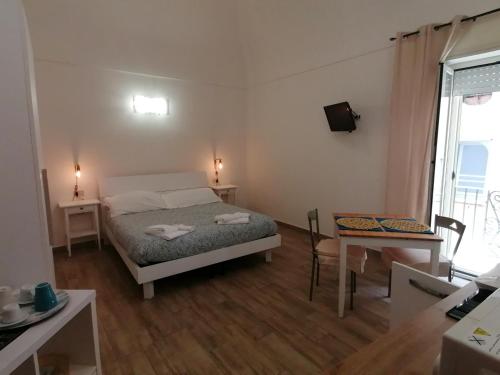 - une petite chambre avec un lit et une table dans l'établissement Cassiopea, à Gaète