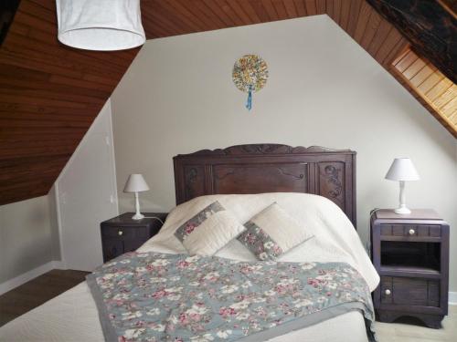 um quarto com uma cama e duas mesas de cabeceira em LES BRUYERES em Scrignac