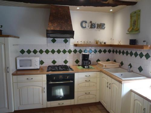 a kitchen with a stove and a microwave at LES BRUYERES in Scrignac