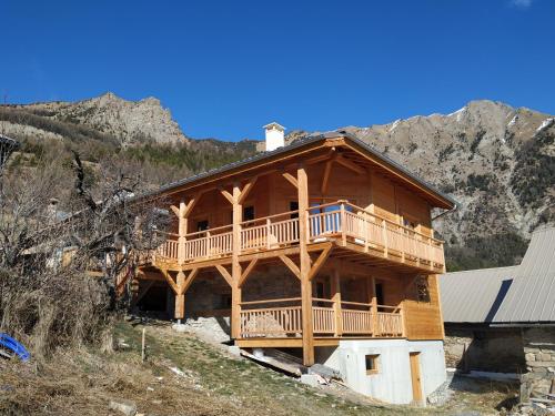 レ・ゾルにあるCHALET ARLETTEの山の上にバルコニー付きの大きな木造家屋