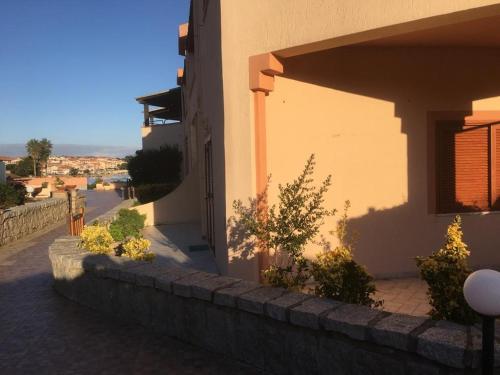 a building with a stone wall next to a street at Case sul mare in Palau